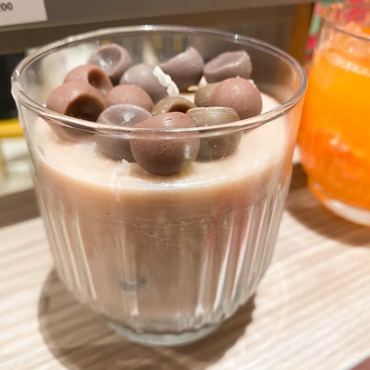 Iced Latte candle — creamy wax latte in a fluted glass topped with wax chocolates