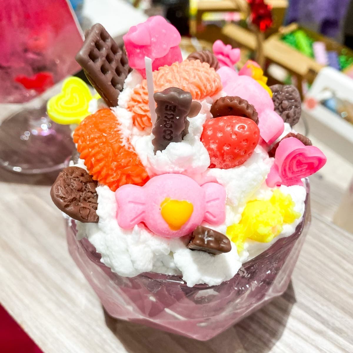 Sundae candle piled with wax whipped cream, candies, strawberries and a waffle